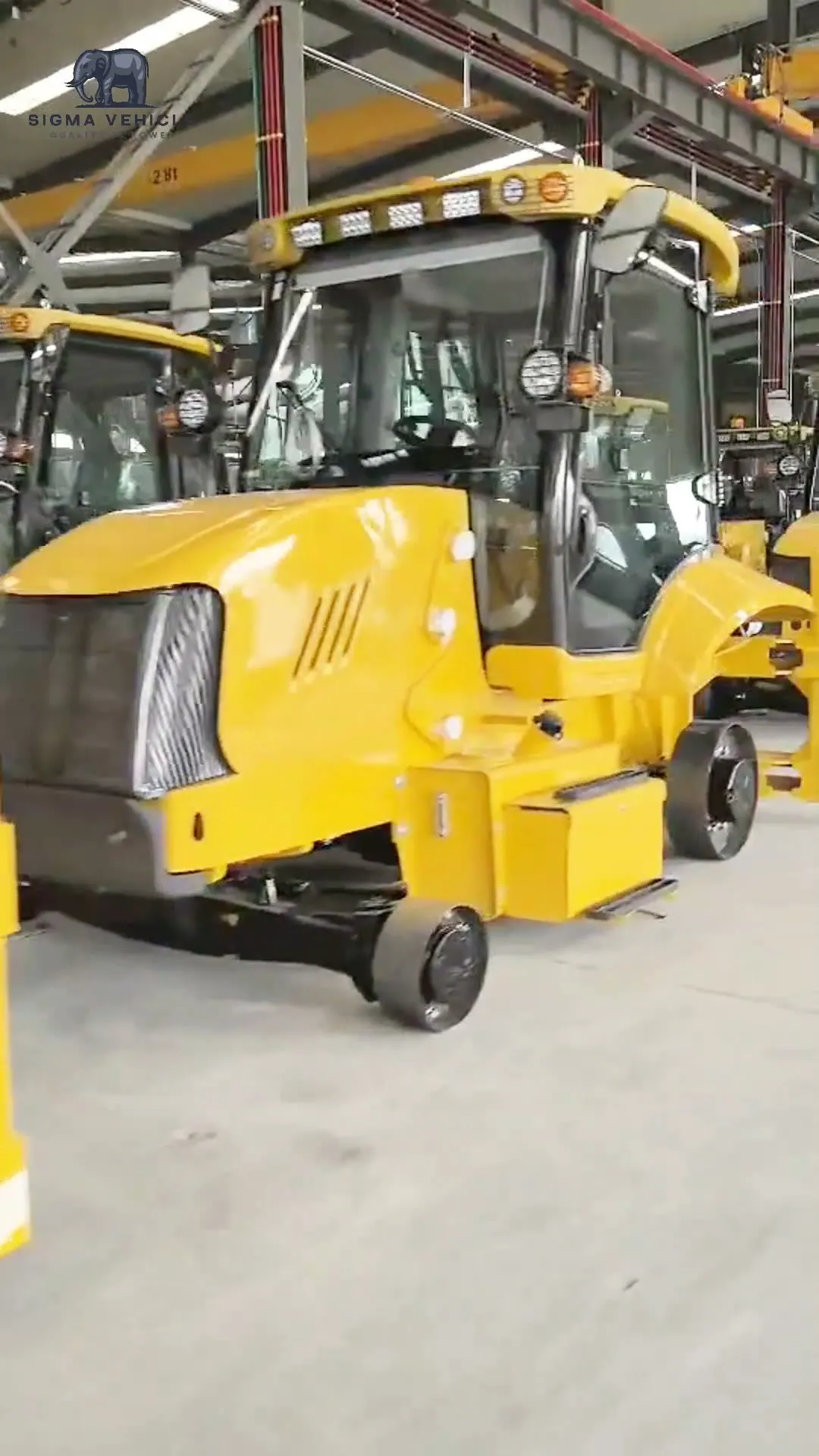 Yellow loaders lined up inside the workshop before shipment